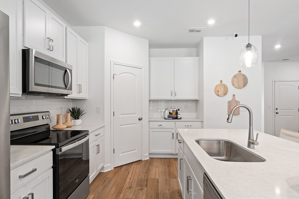 A kitchen with white cabinets.