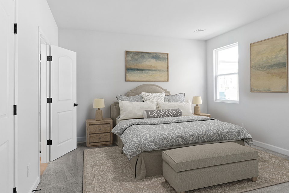 A bedroom with a bed and a bench.