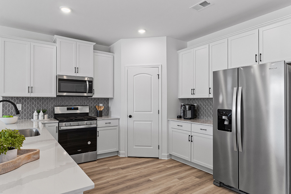 A kitchen with white cabinets.