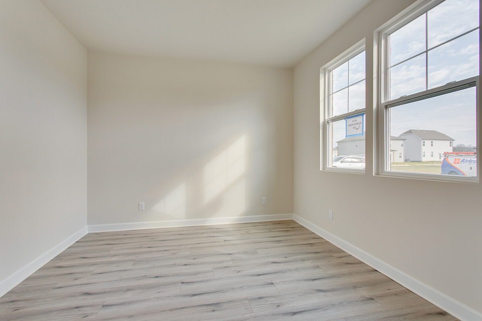 A room with windows and a wood floor.