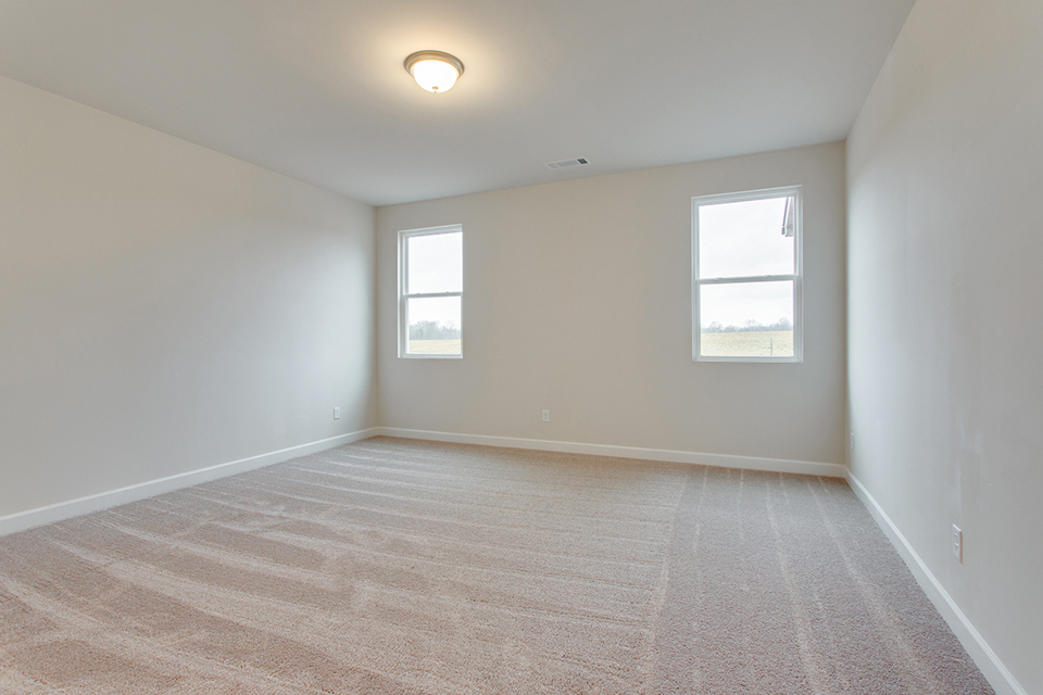 A room with a wood floor and a light on the wall.