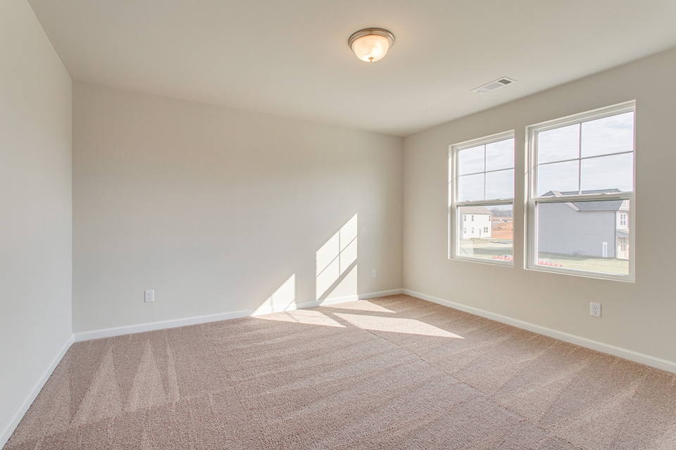 A room with a window and a carpet.