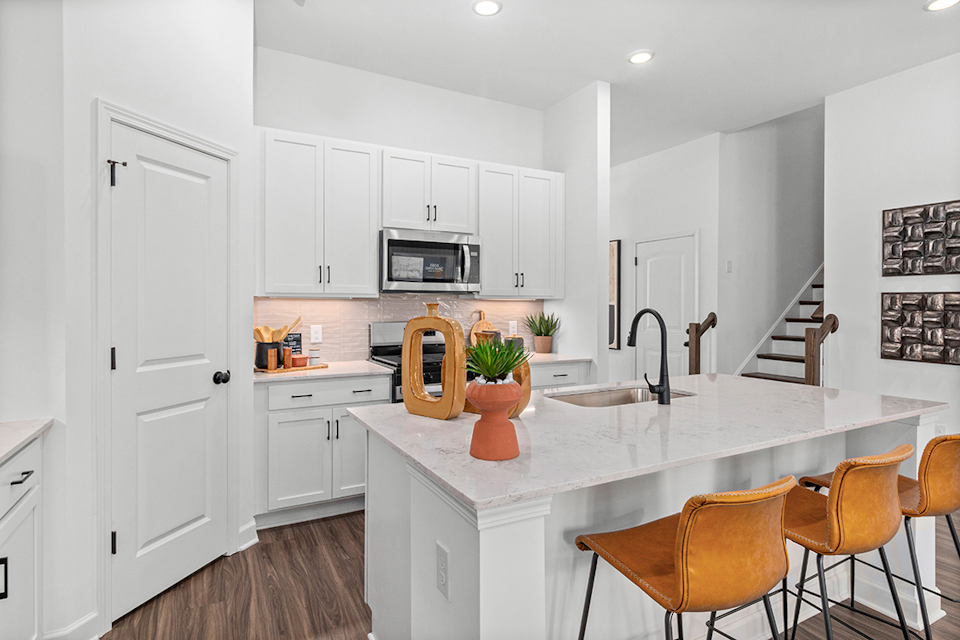 A kitchen with white cabinets.