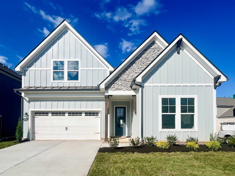 A white house with a garage with American Gothic House in the background.