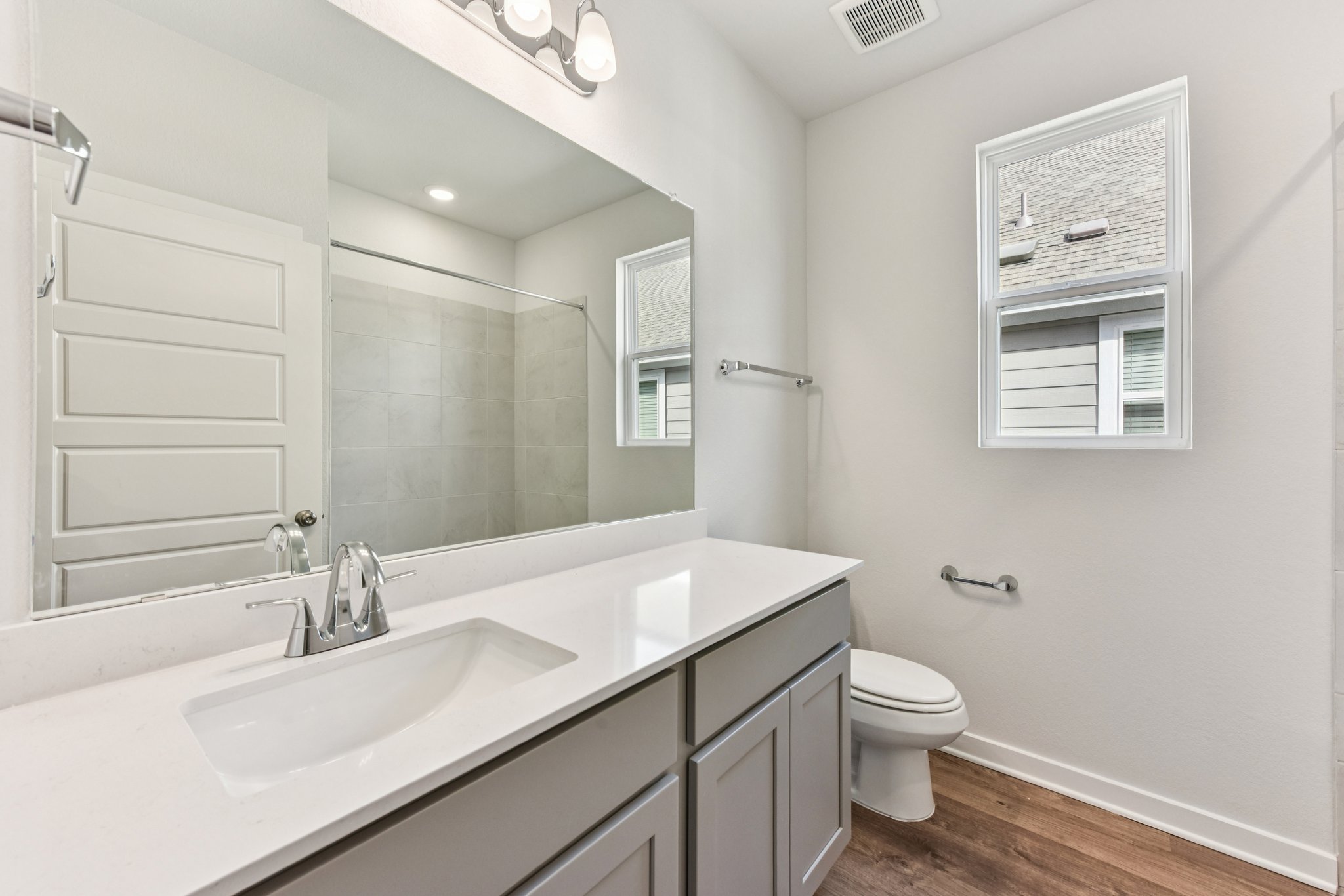 A bathroom with a sink toilet and mirror.