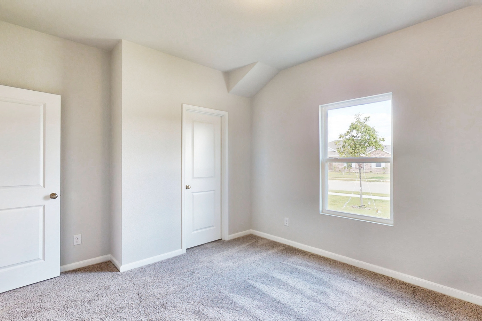 A room with white doors and a tree in the window.