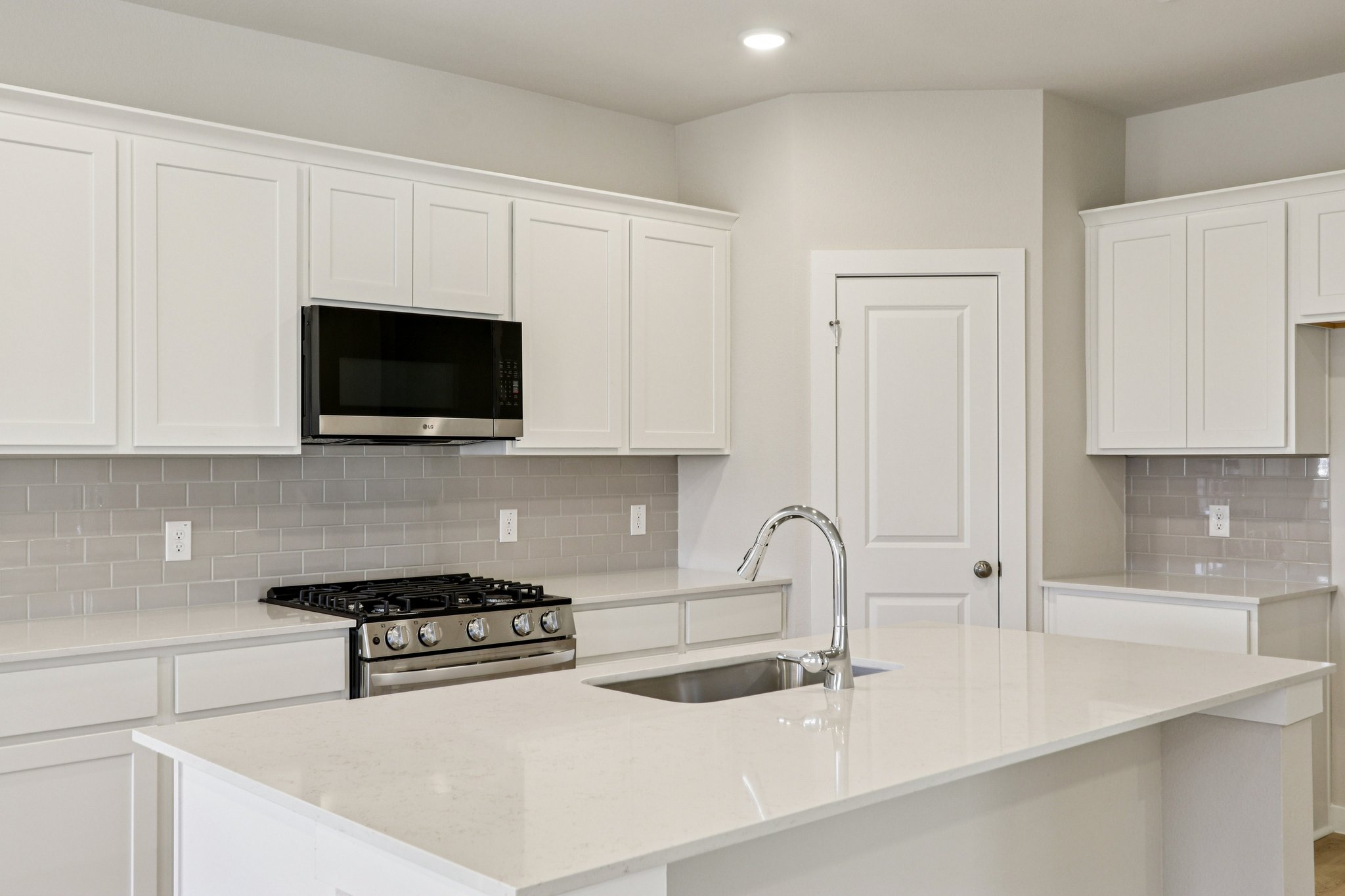A kitchen with white cabinets.