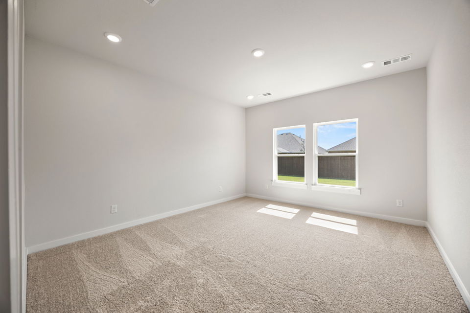 A room with a carpet and windows.