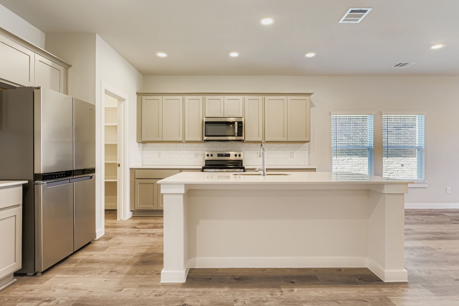 A kitchen with white cabinets.