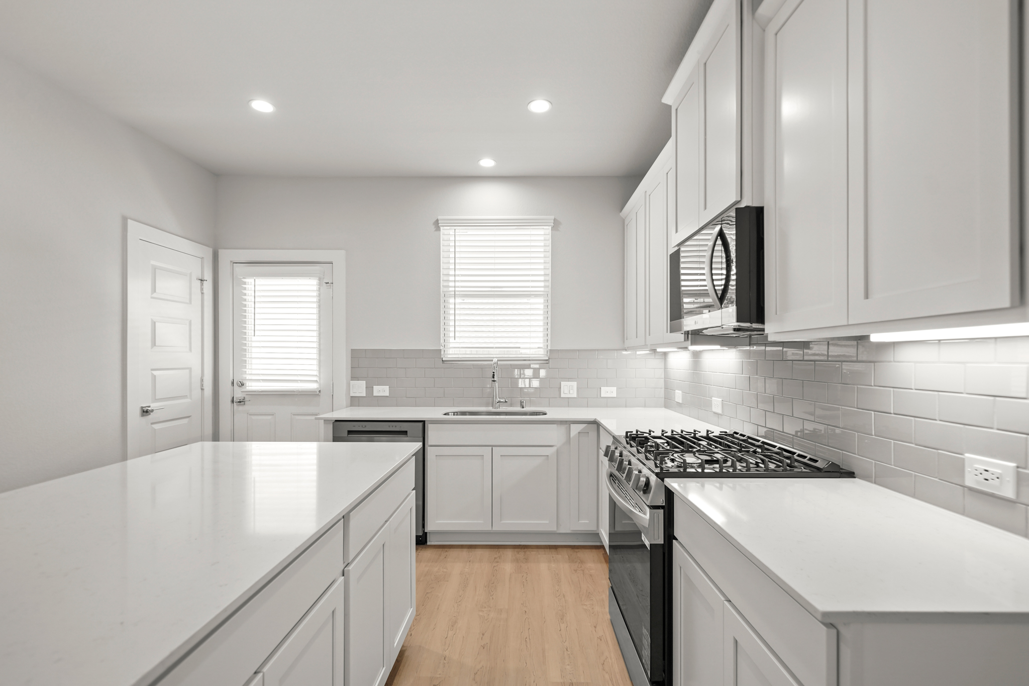 A kitchen with white cabinets.