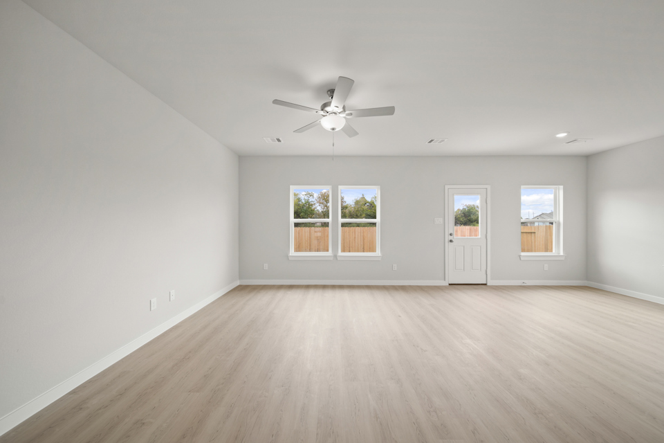 A room with a ceiling fan and a wood floor.