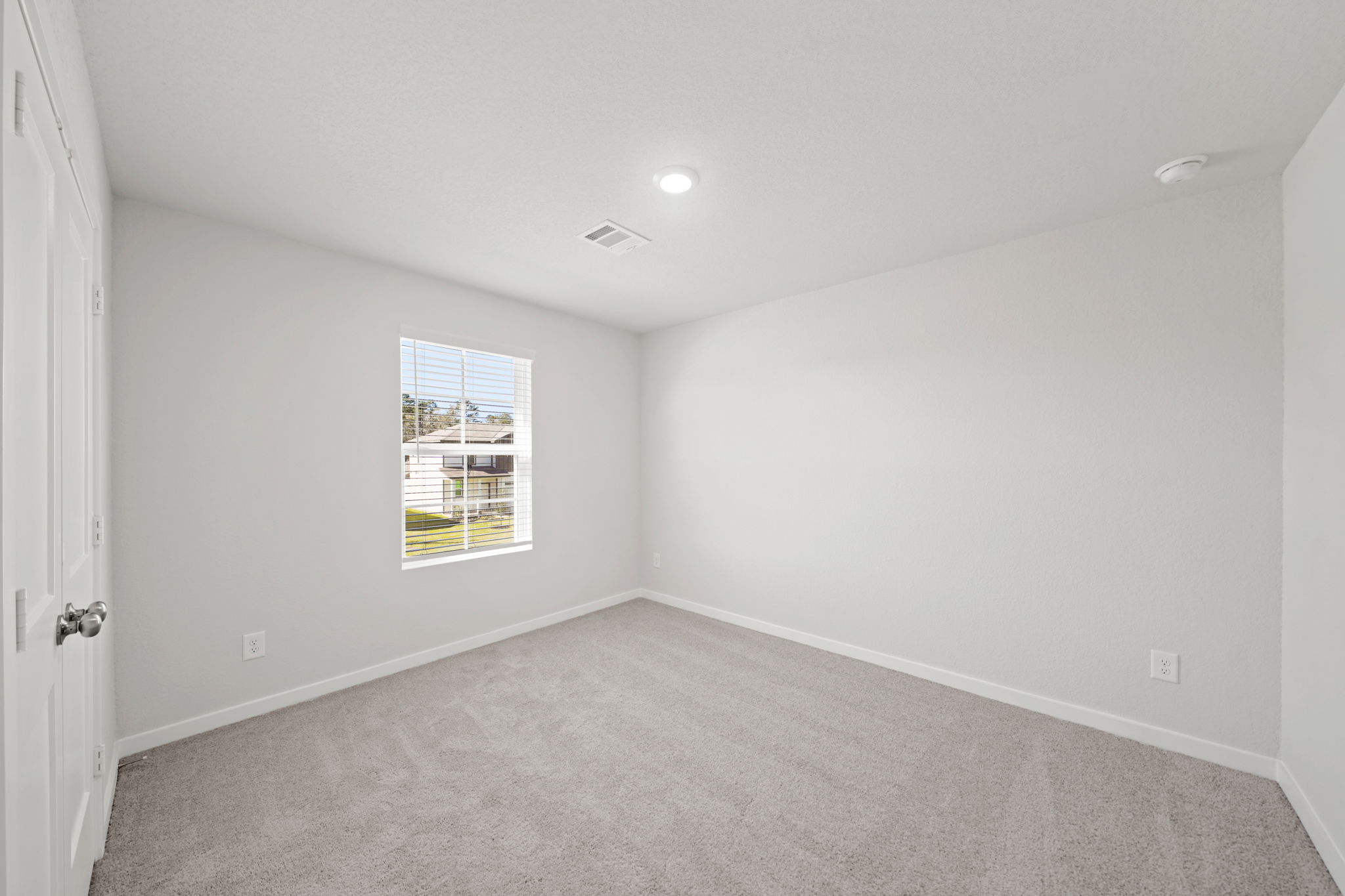 A room with a carpet and a window.