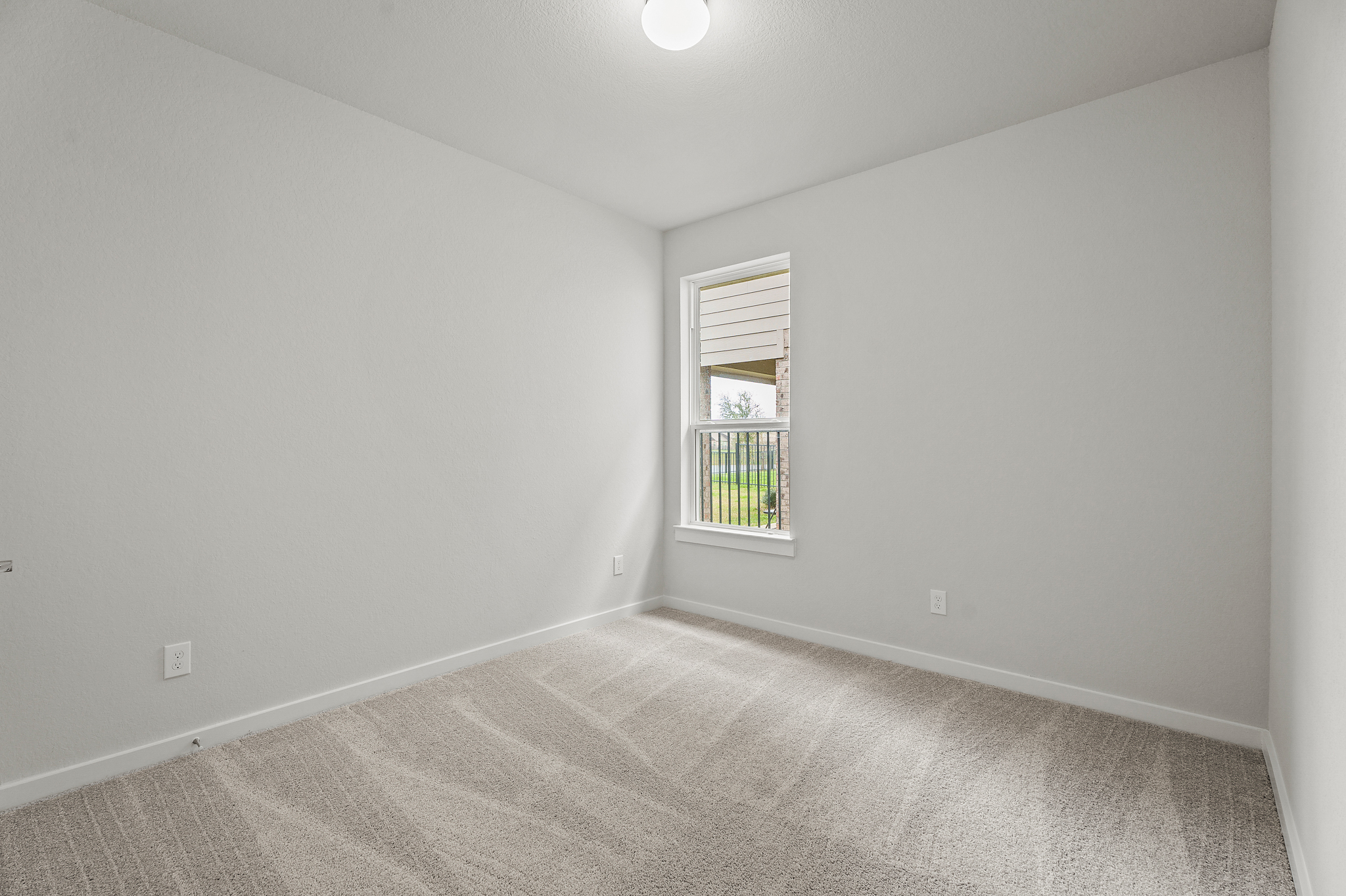 A room with a window and carpet.