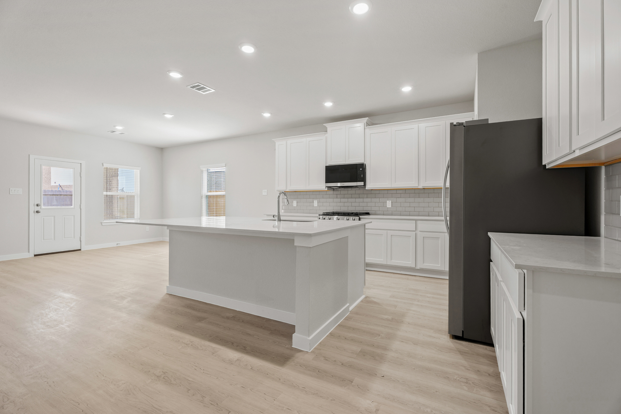 A kitchen with white cabinets.