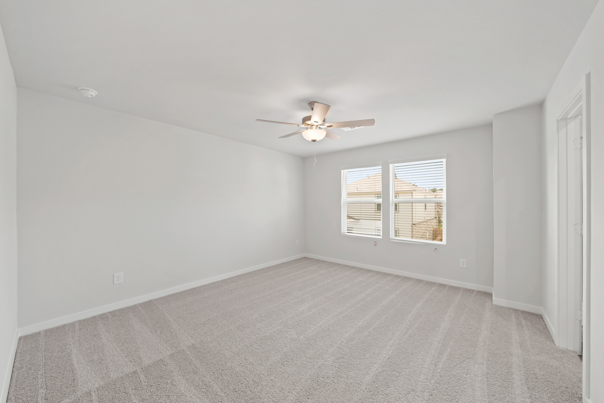 A room with a ceiling fan and a window.