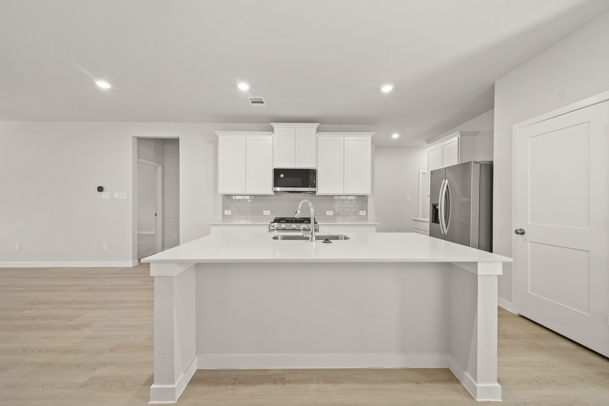 A kitchen with white cabinets.