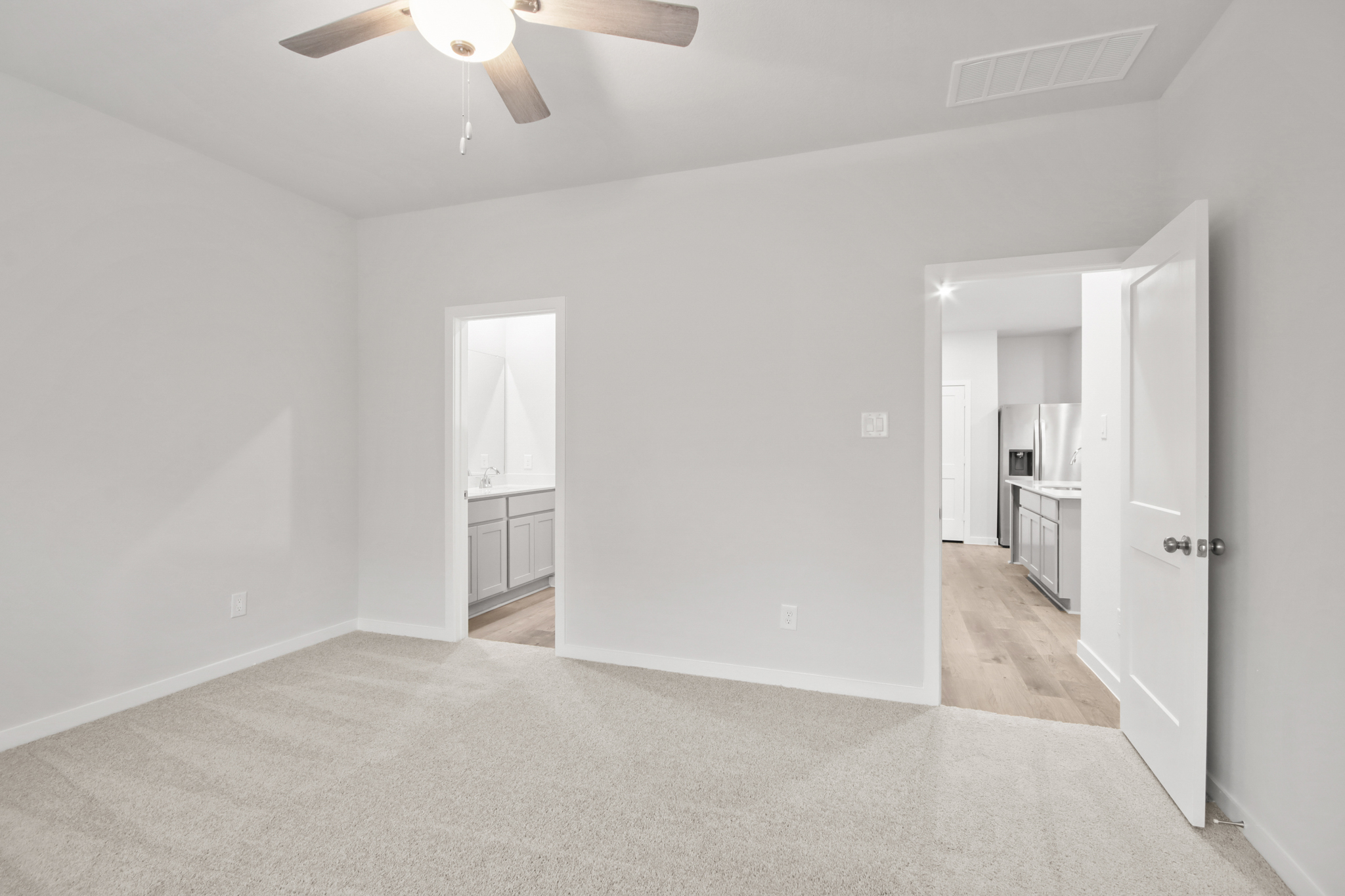 A room with a ceiling fan and a door.