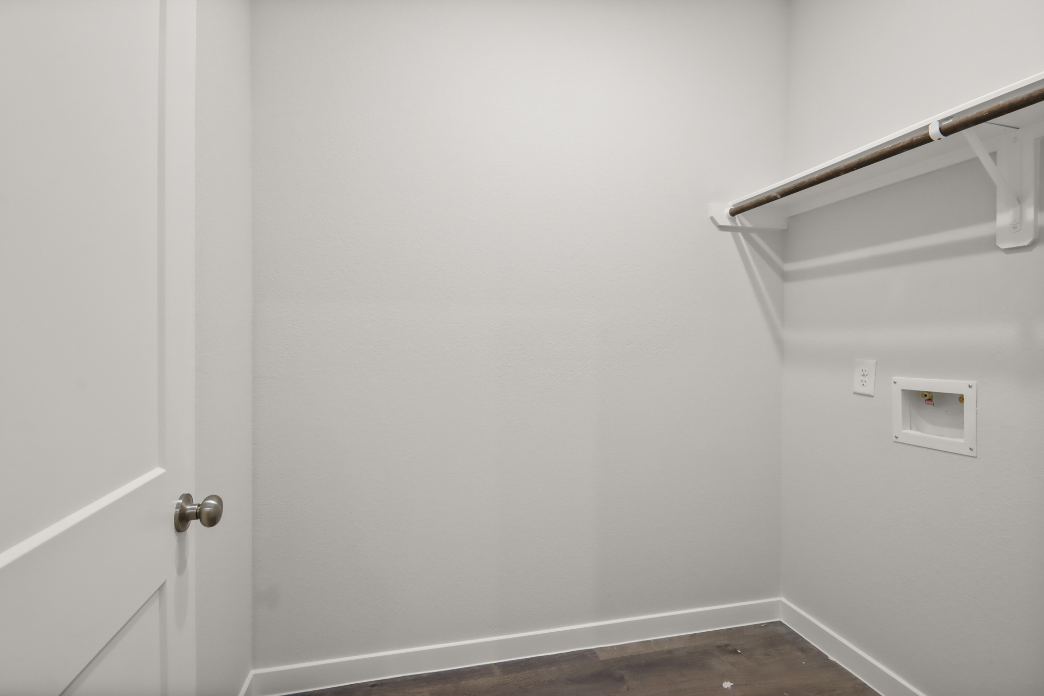 A white wall with a metal bar.