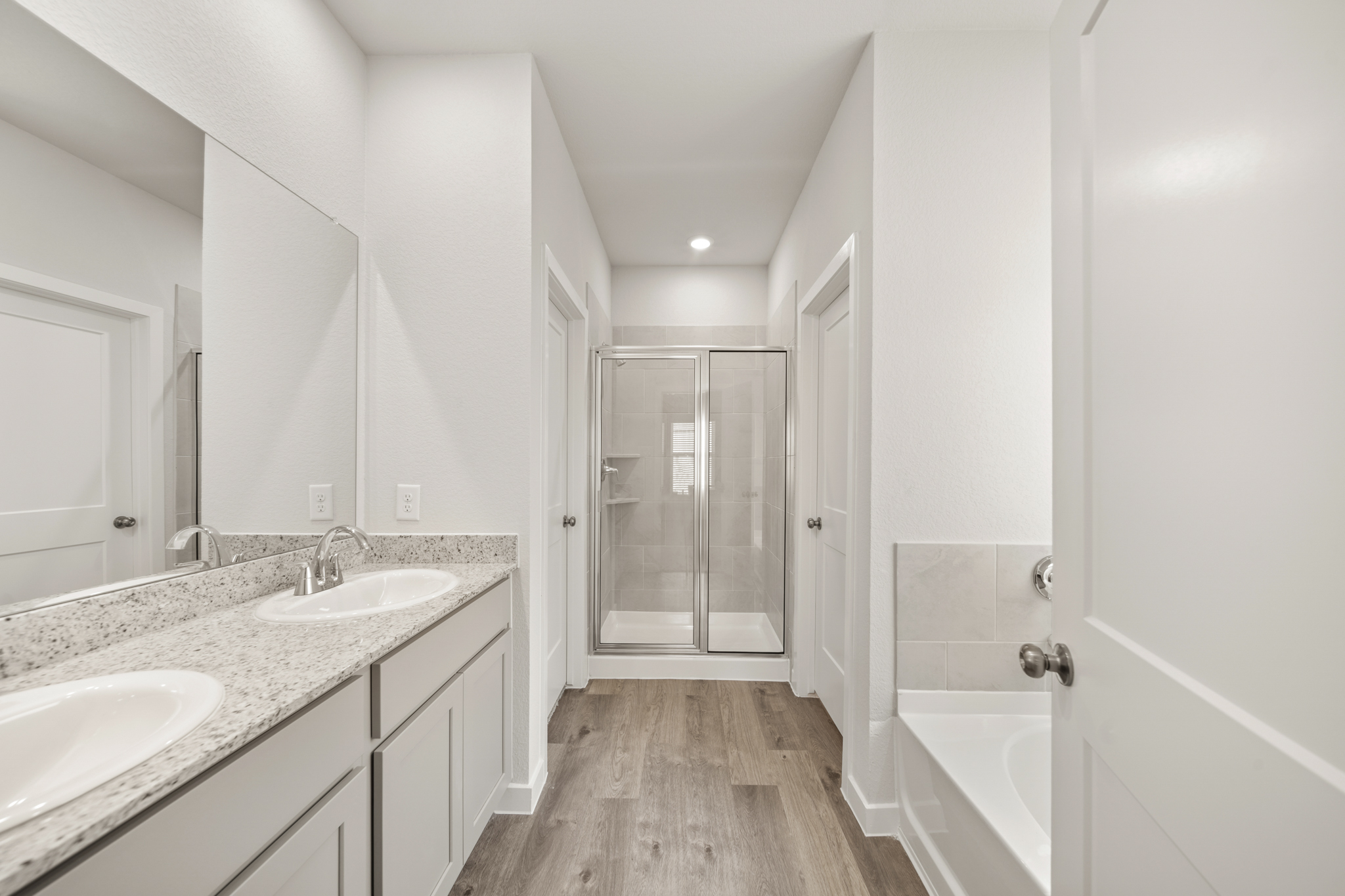 A bathroom with a tub sink and a mirror.
