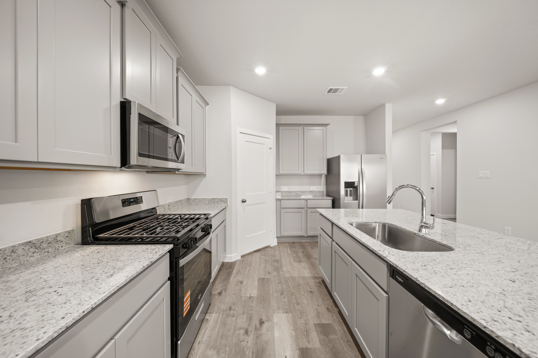 A kitchen with white cabinets.