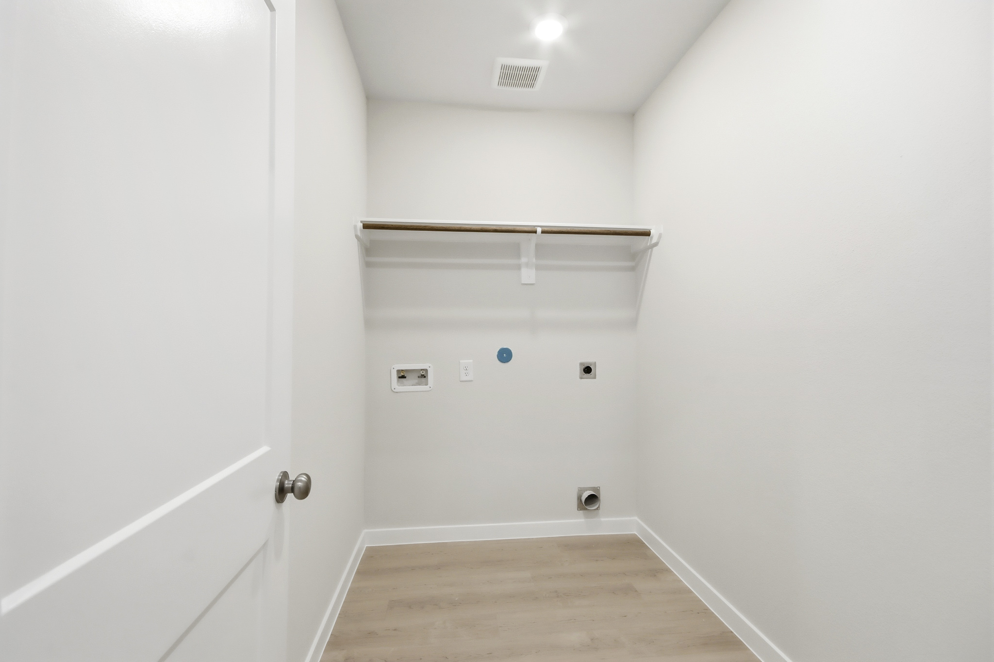 A white room with a wood floor.