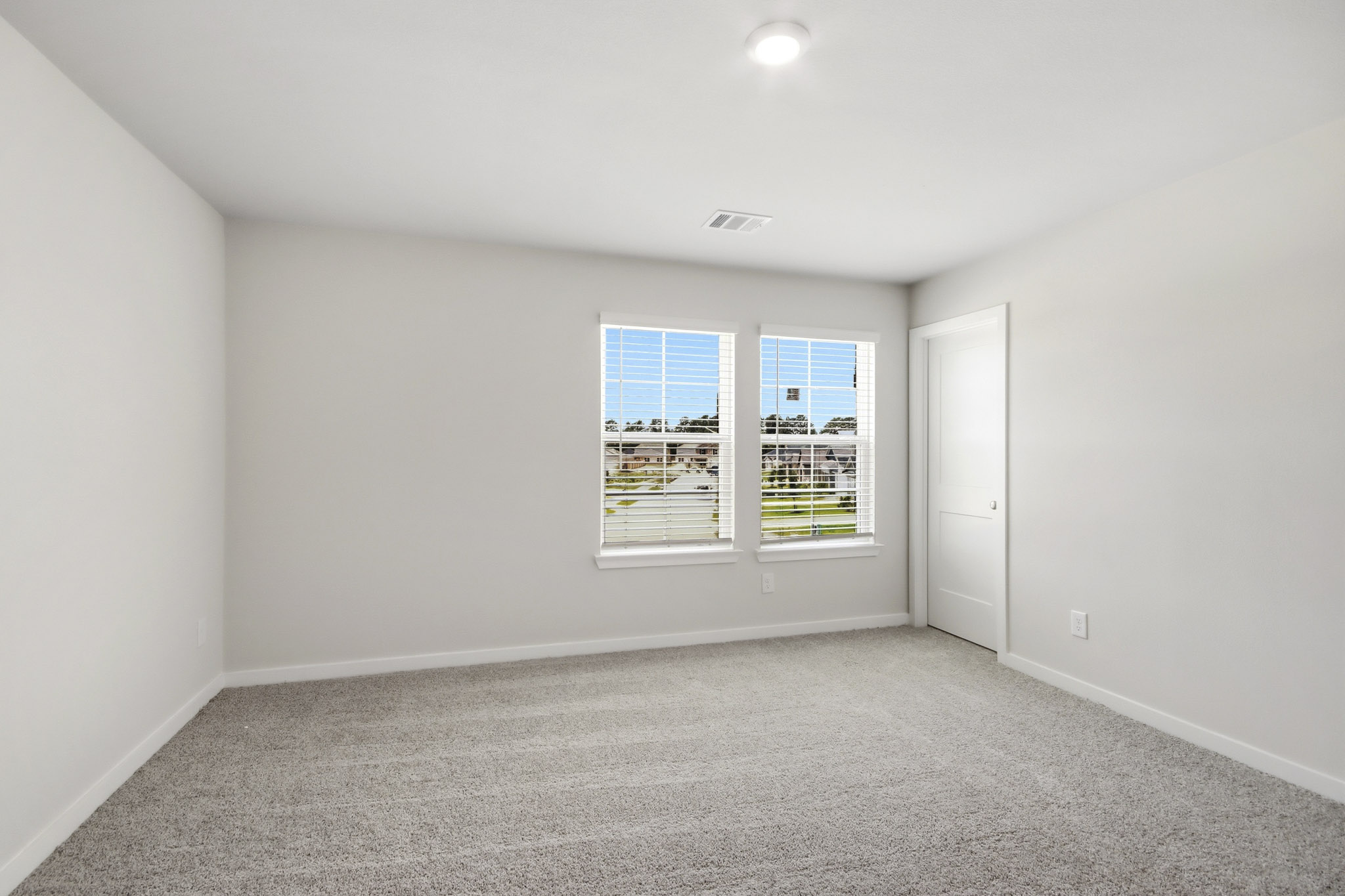 A room with a window and a carpet.