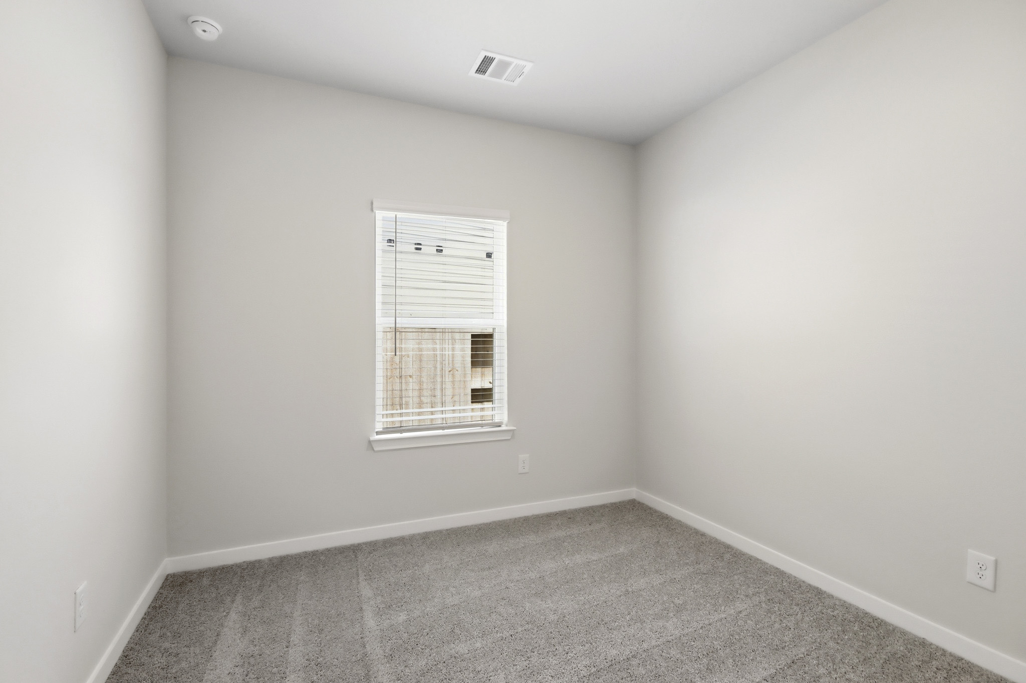 A room with a window and a vent.