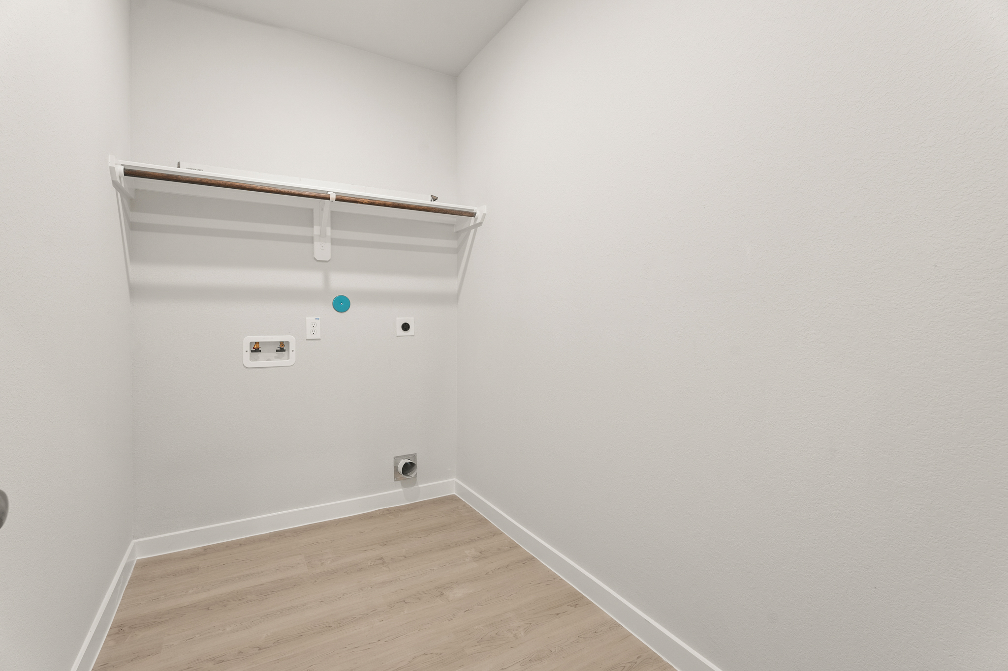 A white wall with a wood floor.