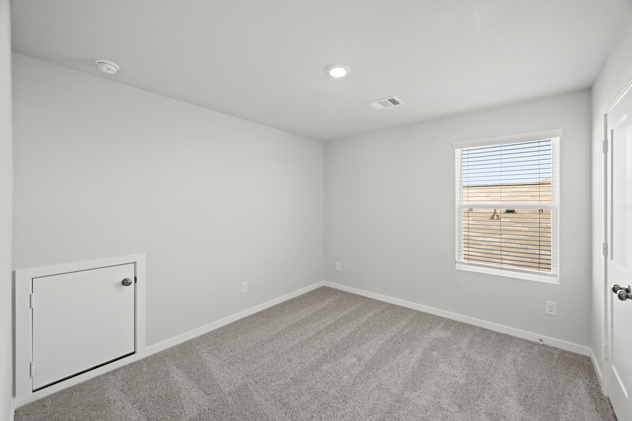 A room with a carpet and a window.