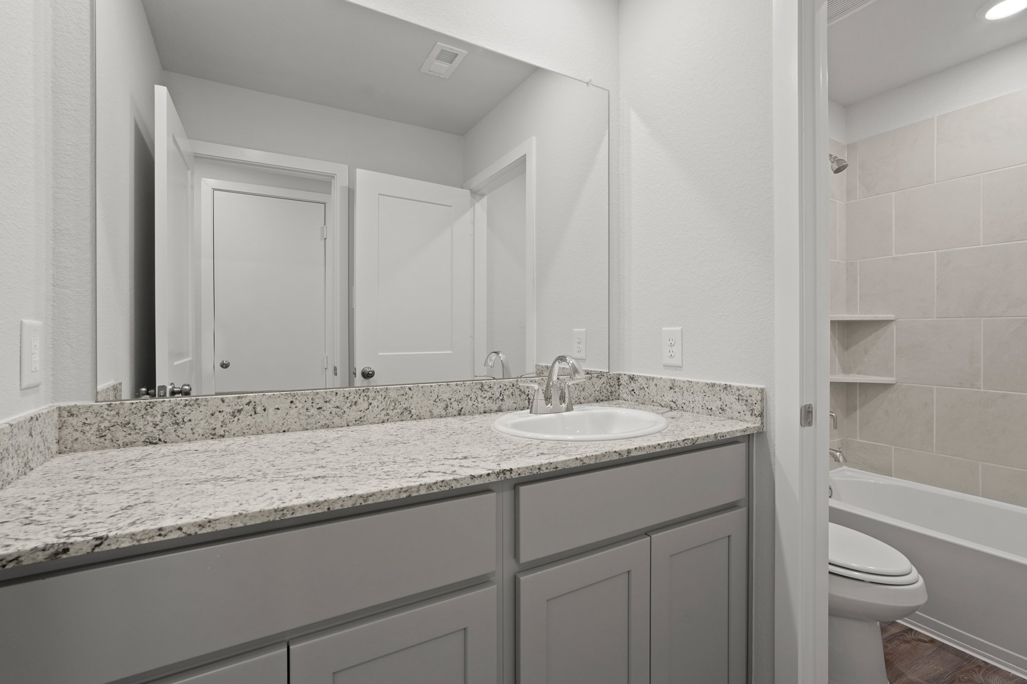 A bathroom with marble countertop.