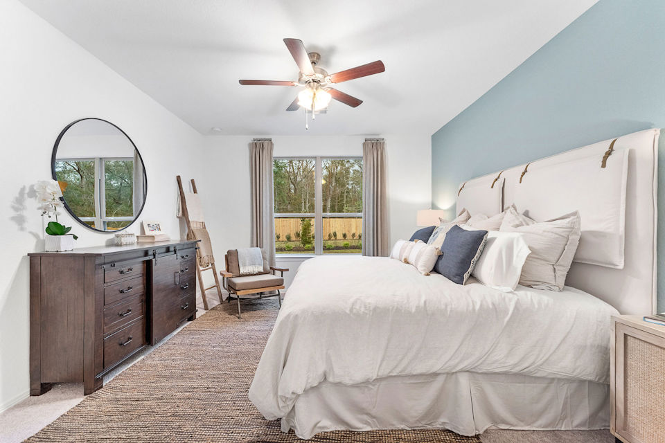 A bedroom with a bed and a fan.