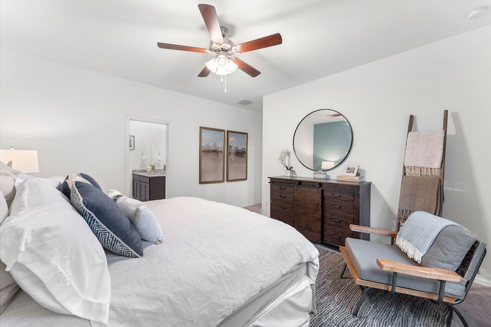 A bedroom with a bed and a fan.