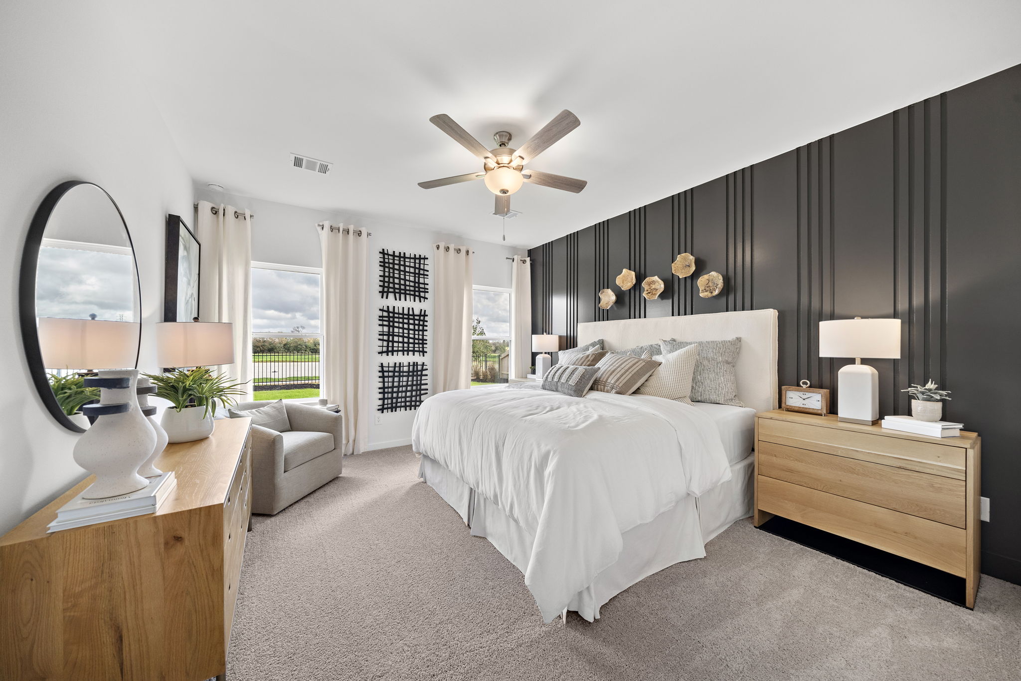 A bedroom with a large bed and a large fan.