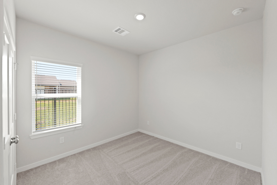 A room with a window and a rug.