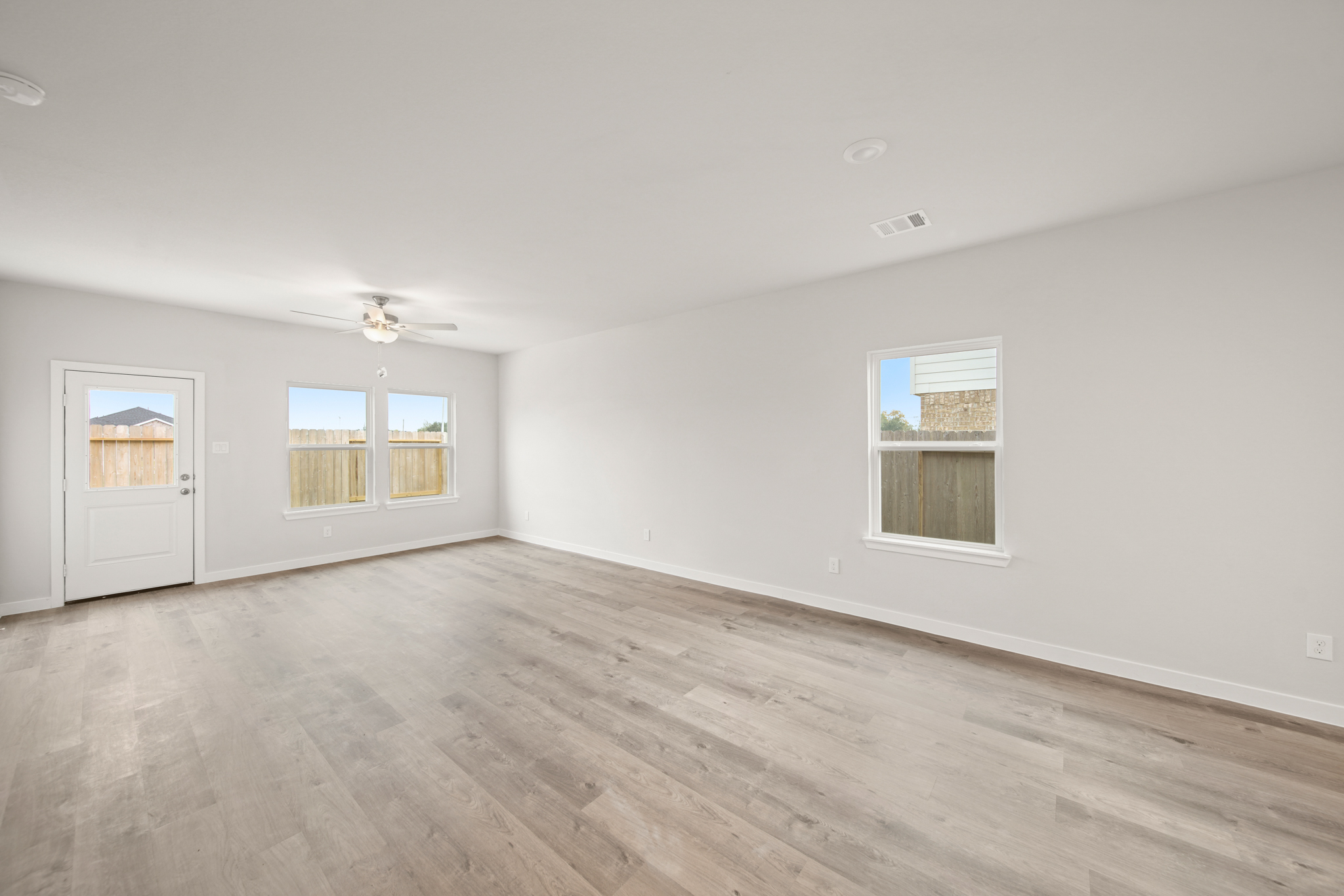 A room with a wood floor and windows.
