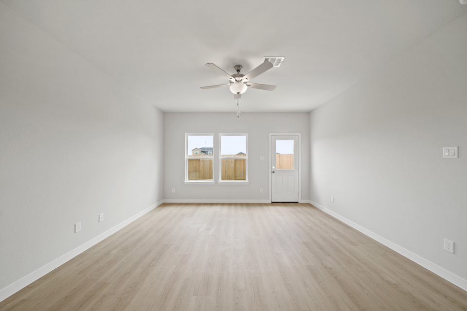 A room with a wood floor and a ceiling fan.