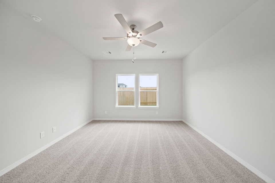 A room with a ceiling fan and a window.