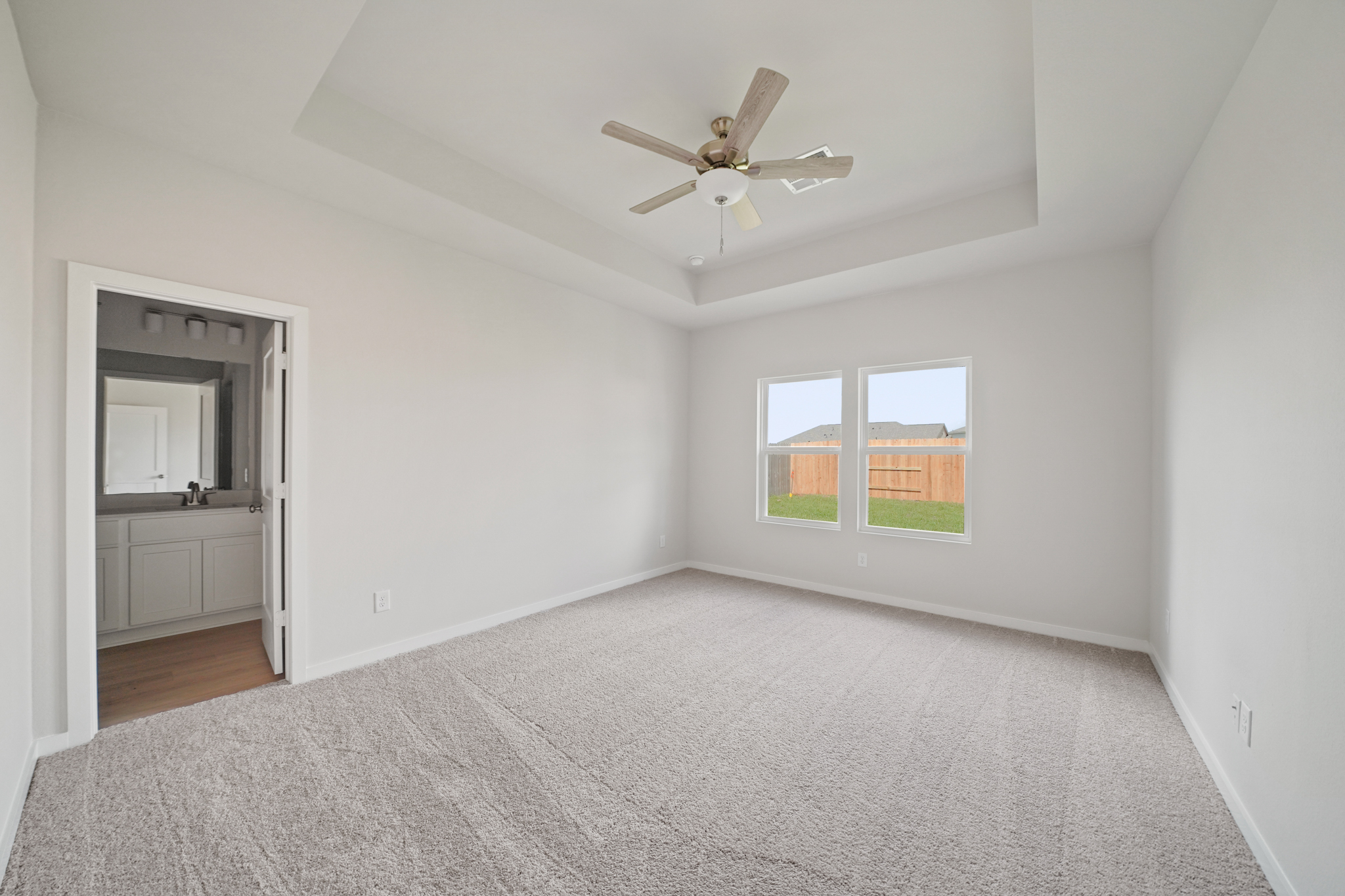 A room with a ceiling fan and a window.