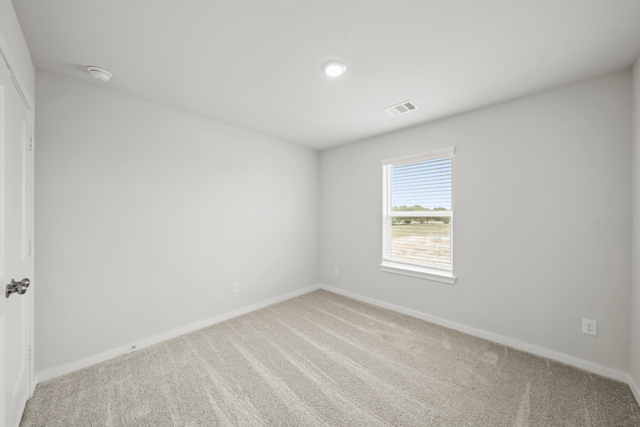 A room with a carpet and a window.