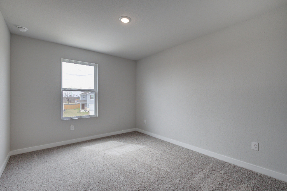 A room with a window and a carpet.