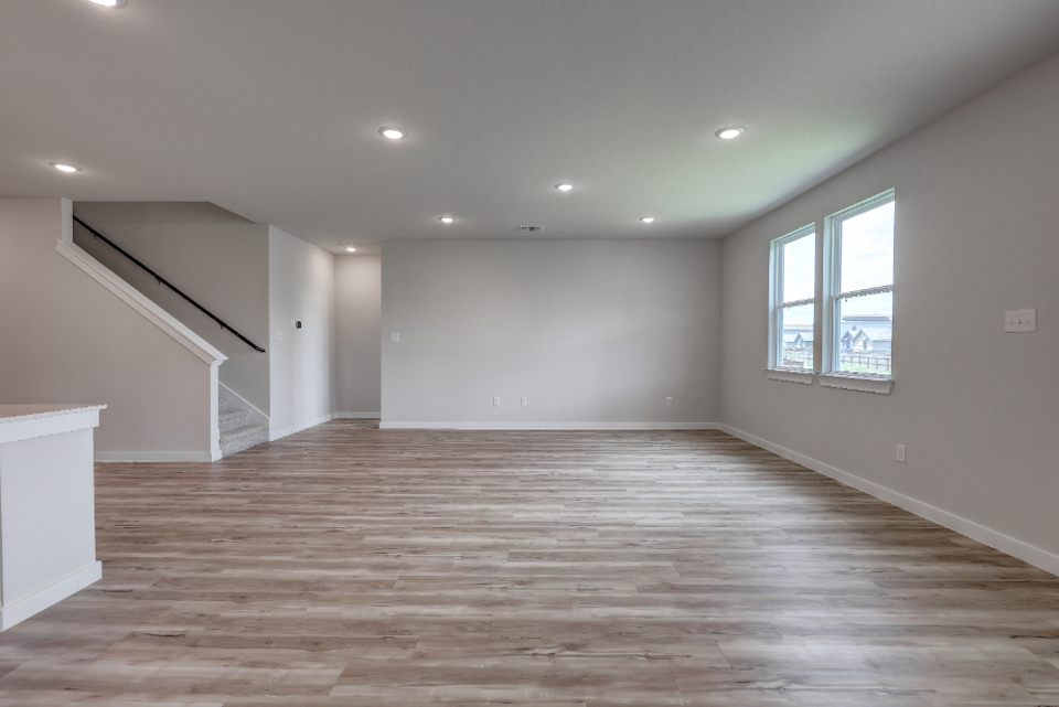 A room with a wood floor and windows.