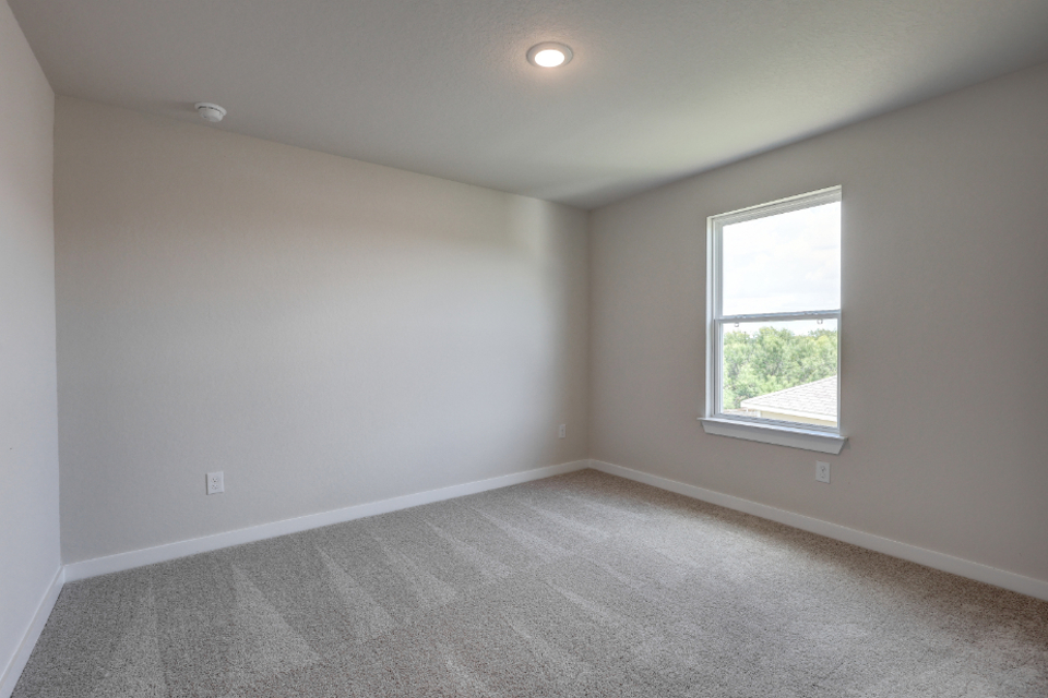 A room with a window and a carpet.