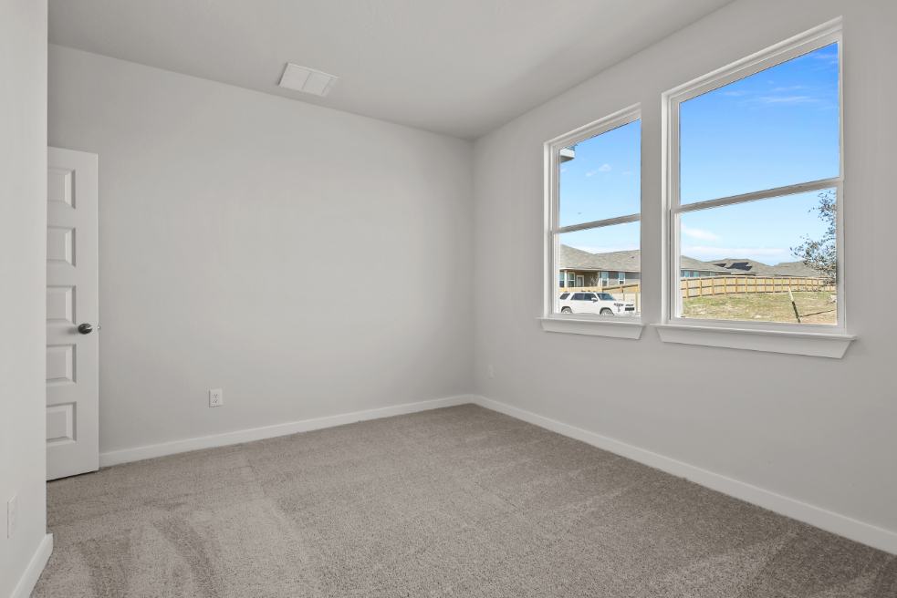 A room with a window and a door with a view of the water.