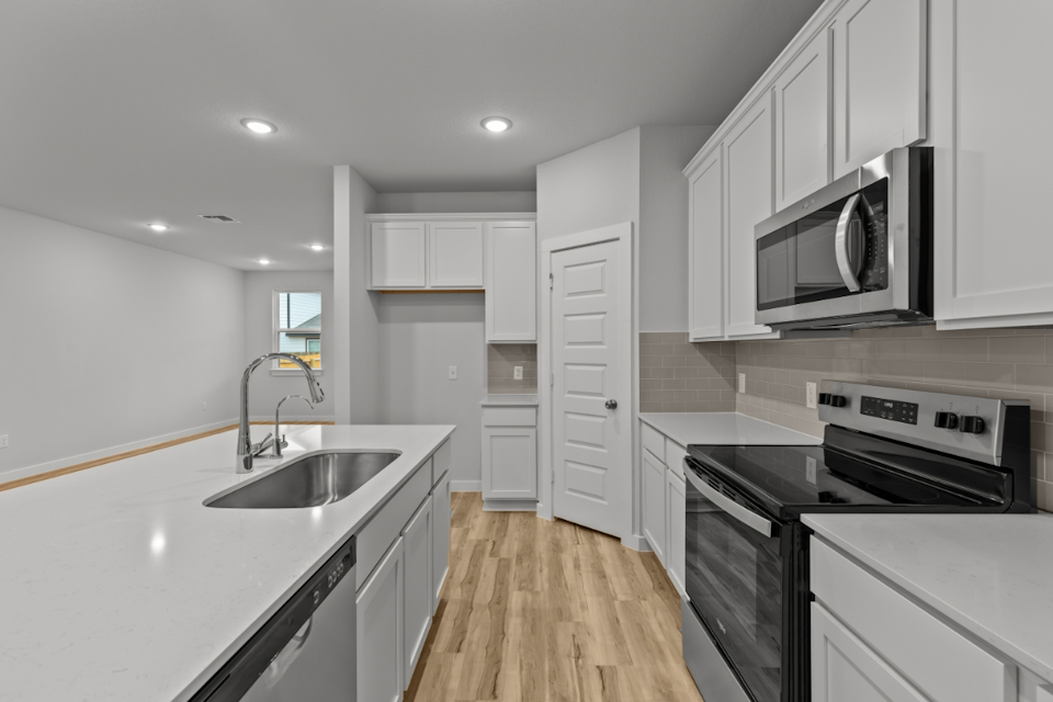 A kitchen with white cabinets.