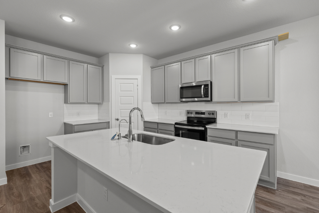 A kitchen with white cabinets.