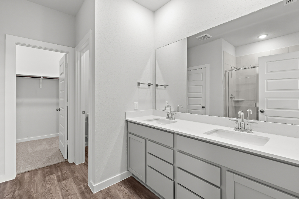A bathroom with white cabinets.