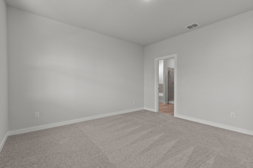 A room with a carpet and a door.