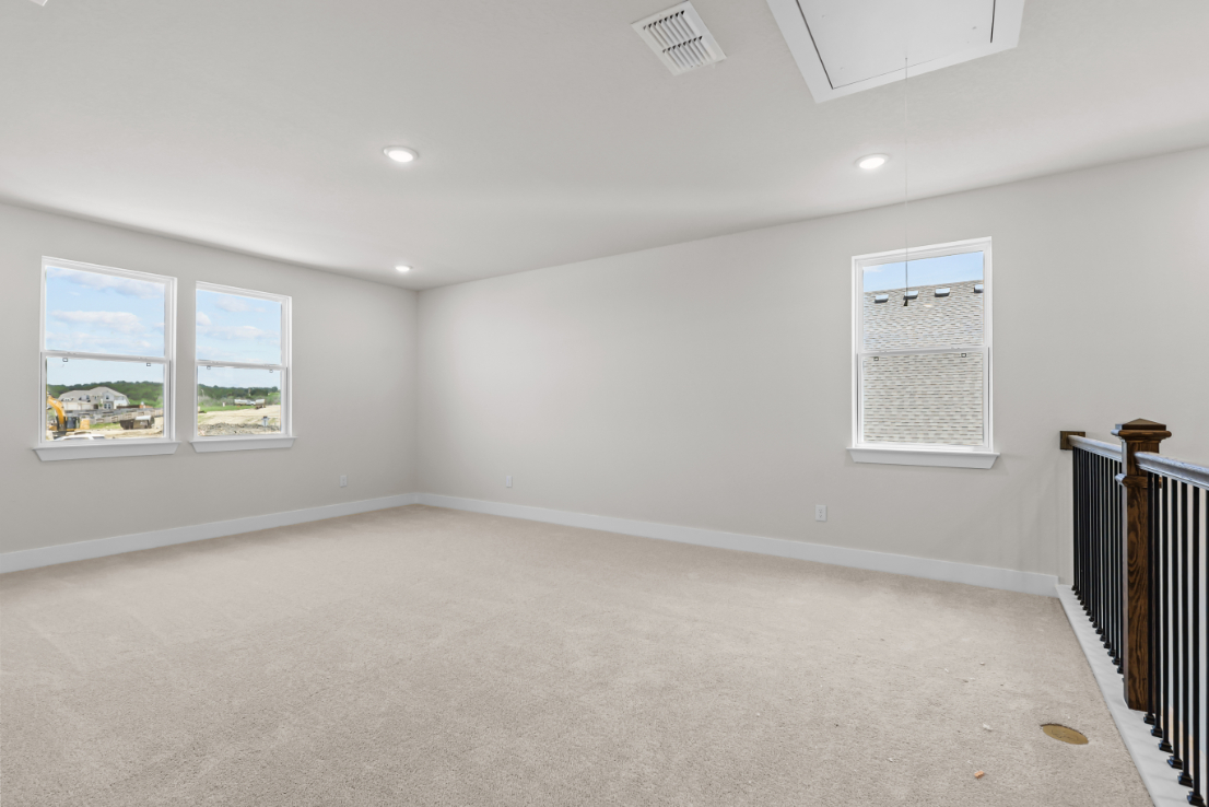 A room with a white wall and windows.