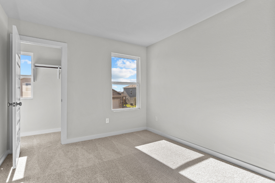 A room with a window and a rug.