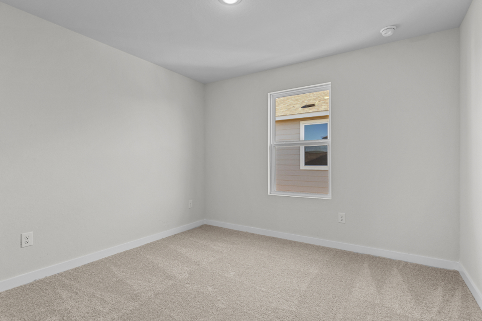 A room with a window and carpet.